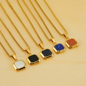 Close-up of five colorful square pendants with 18k gold plating on yellow velvet fabric