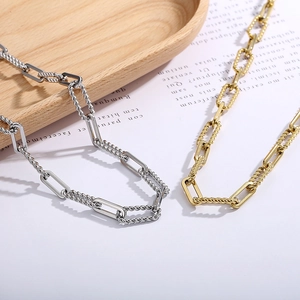 Detail view of gold and silver mixed chain necklaces with OT buckle and twisted link design