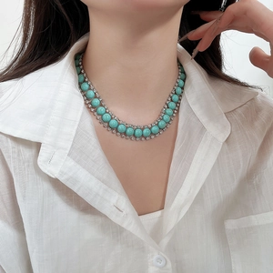 Détail d'un collier bohème double rang en turquoise avec cristaux sur un mannequin