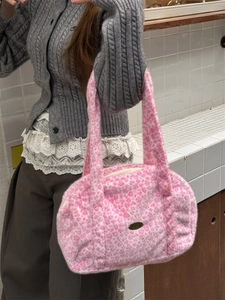 Sac fourre-tout en peluche léopard rose avec plaque de marque porté par le mannequin