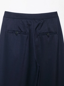 Macro shot of dark blue trousers featuring twill texture and back buttoned welt pocket