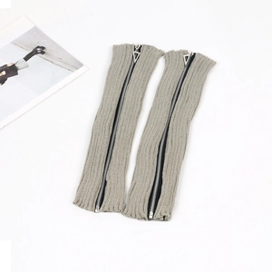 Detail of grey ribbed knit leg warmers featuring full-length zippers and metal sliders