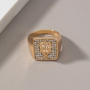 Macro shot of gold lion head square ring with sparkling stones on textured leather