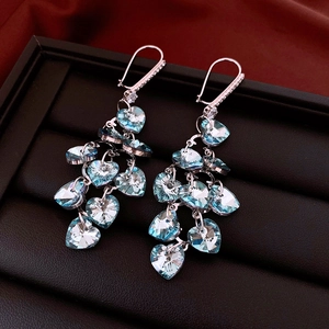 Macro shot of silver heart tassel earrings with light blue crystals on display box
