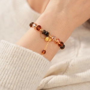 Gros plan d'un bracelet gourde en œil de tigre avec perles ambrées et détails dorés