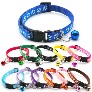 Detail of colorful nylon pet collars with white claw prints and small metal bells