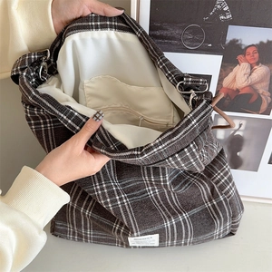 Close-up of the plaid tote bag interior with beige lining and a zipper pocket