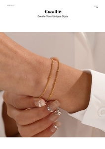 Close-up of gold beaded double-layer stainless steel bracelet on woman's wrist