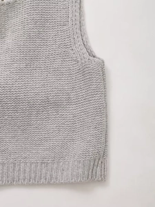 Gros plan du gilet en maille gris clair avec ourlet côtelé et texture épaisse