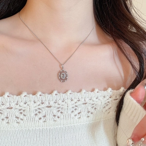 Close-up of elegant silver zircon oval flower pendant on a snake bone chain necklace