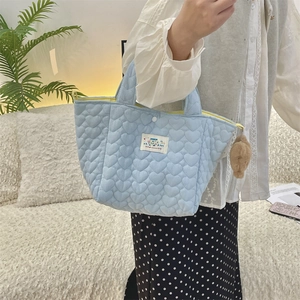 Quilted light blue heart tote bag with yellow zipper and brown plush ball charm