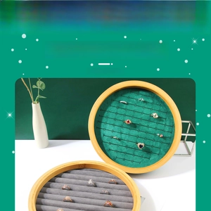 Detail view of round bamboo jewelry tray with dark green velvet slots for ring display