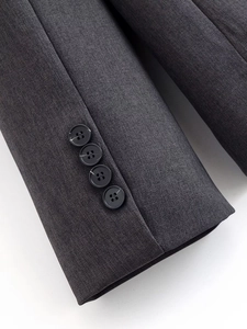 Gros plan sur les poignets d'un costume gris foncé avec quatre boutons et tissu sergé