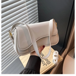 Detail view of the white faux leather shoulder bag with adjustable golden metal buckle