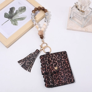 Close-up of leopard print card holder with wooden beads wristlet and tassel keychain