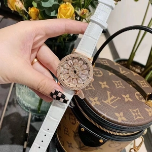 Detail of luxury spinning flower dial watch with crystal bezel and white leather strap