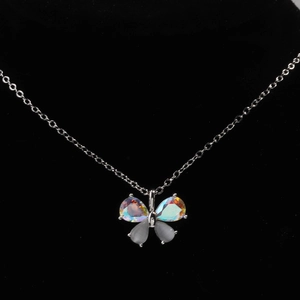 Macro shot of silver butterfly necklace with iridescent opal and sparkling crystal wings