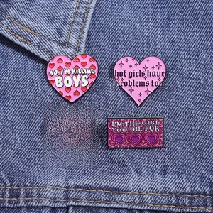Pink punk metal enamel pins set with heart shapes on denim jacket background