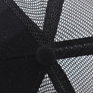 Macro shot of black trucker hat top featuring breathable mesh and reinforced stitching