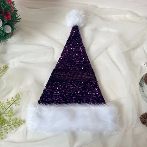 Close-up of purple sequined Christmas hat with soft white plush trim on fabric background