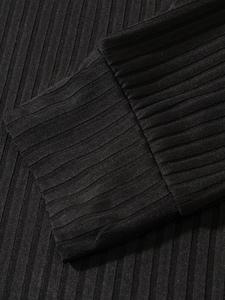 Macro shot of men's black ribbed knit polo fabric showing texture and stitching details