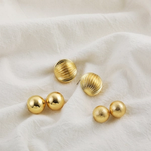 Golden stainless steel earring set featuring smooth, ribbed, and matte textured spheres