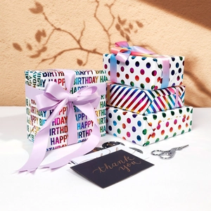 Rainbow birthday gift wrapping paper set with colorful dots, stripes and purple ribbons