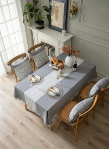 Close-up of grey Christmas tablecloth featuring reindeer jacquard and fringe details