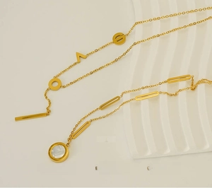 Detailed macro of 18k gold plated stainless steel necklaces with Roman numeral pendant