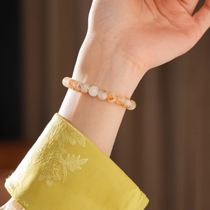 Détail d'un bracelet en perles de citrine jaune sur le poignet d'une femme élégante