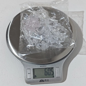 Macro shot of 60.5g clear acrylic snowflake pendants on a digital scale for weight check