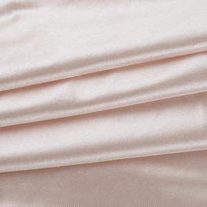Détail du tissu satin rose champagne luxueux montrant la texture lisse et le tissage