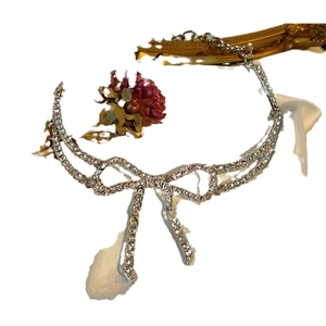 Elegant silver choker necklace featuring a sparkling rhinestone bow and fringe tassels