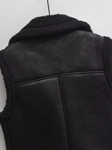 Gros plan du gilet en simili cuir noir montrant le col en laine de mouton et le dos