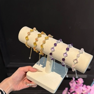 Vue détaillée des bracelets en perles à trèfle colorés présentés sur un support bijoux