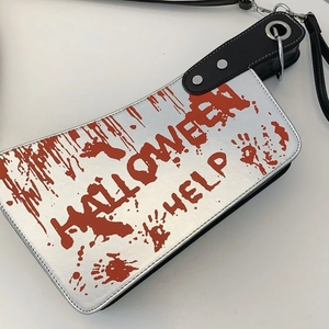 Close-up of clever meat cleaver handbag with red bloodstains and Halloween help text