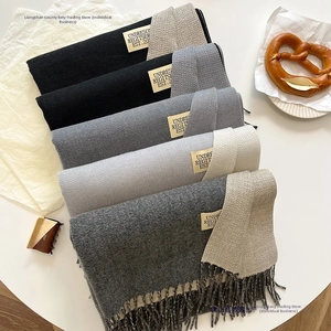 Flat lay of cashmere-like scarves in grey tones with tassels and twill knit texture