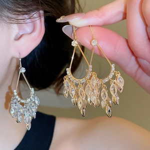 Detail of gold-plated tassel chandelier earrings with sparkling marquise zirconia crystals