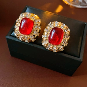 Details von Vintage-Goldohrringen mit rotem Kunstharz-Edelstein und glitzernden Kristallen