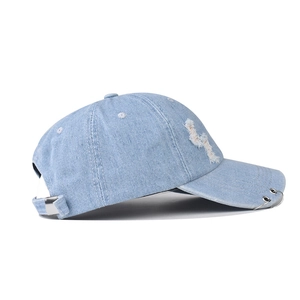 Distressed light blue washed denim baseball cap with trendy silver metal rings and rip details