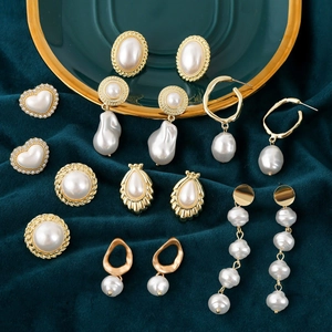 Retro faux pearl gold earrings collection with baroque and heart shapes on velvet