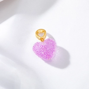 Macro shot of a pink heart pendant with crystals and gold bail for DIY jewelry making
