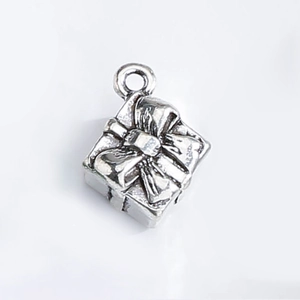 Macro shot of silver gift box charm with embossed ribbon texture for DIY jewelry making