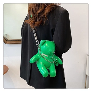 Side view of a green 3D bear-shaped PU leather crossbody bag with silver chain strap