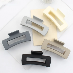 Close-up of large matte hair claws in five neutral colors with square hollow design