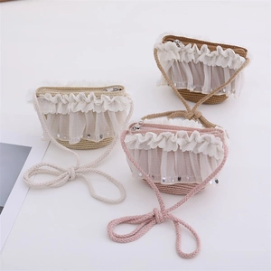 Detailed macro shot of straw crossbody bags with delicate lace trim and sequin accents