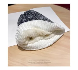 Detail of warm winter knit beanie showing the thick white plush fleece lining for insulation