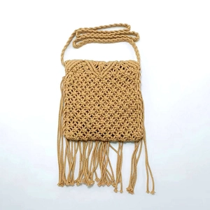 Detailed close-up of woven cotton linen bag with stripes and long decorative fringe tassels