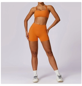 Front view of bright orange high-waist sports bra and compression fitness shorts set