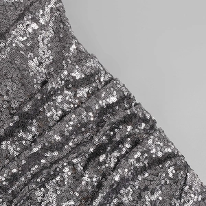 Gros plan de paillettes argentées sur tissu montrant une texture et un fini brillant